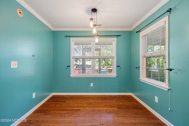 spare room with hardwood / wood-style floors and crown molding