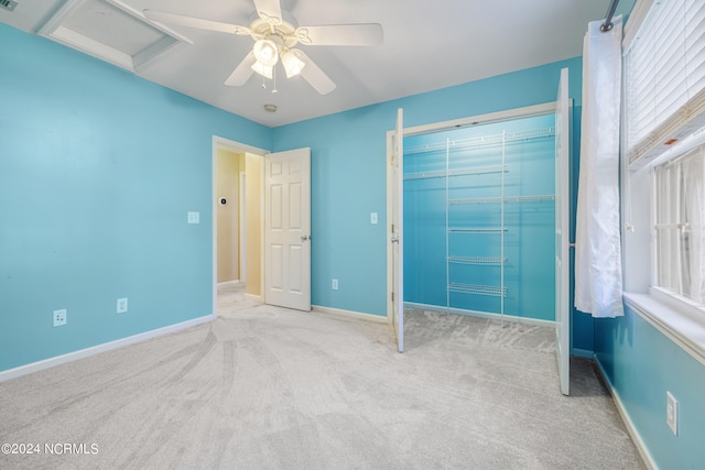 unfurnished bedroom with light carpet, ceiling fan, and a closet