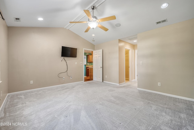 carpeted spare room featuring ceiling fan and vaulted ceiling