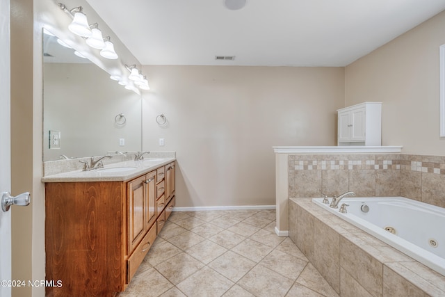 bathroom with vanity, tile patterned flooring, and tiled bath