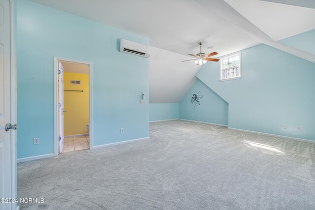 bonus room with ceiling fan, light colored carpet, an AC wall unit, and vaulted ceiling