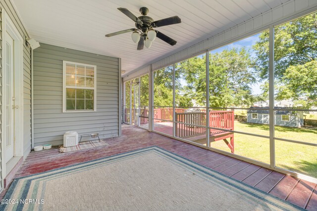 unfurnished sunroom featuring ceiling fan