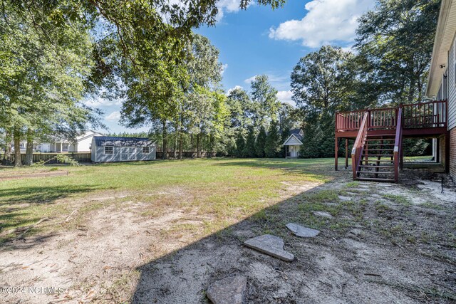 view of yard with a wooden deck and a shed