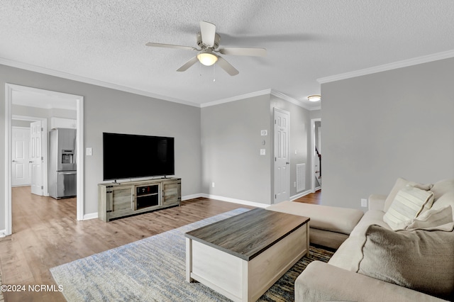 living room with ceiling fan, hardwood / wood-style flooring, crown molding, and a textured ceiling