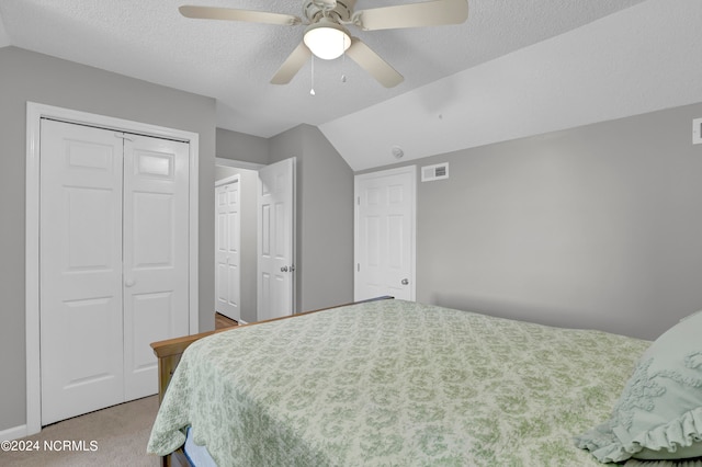 carpeted bedroom featuring a textured ceiling, vaulted ceiling, and ceiling fan