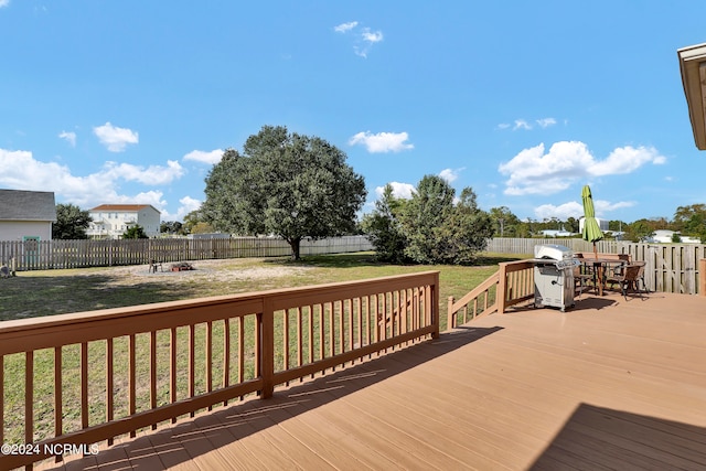 wooden terrace with grilling area and a yard