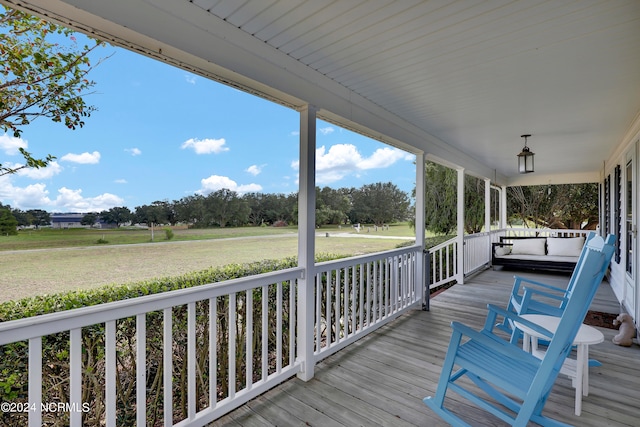 deck featuring a yard and covered porch