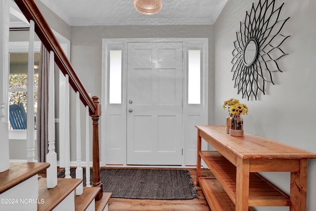 foyer featuring light wood-type flooring and crown molding