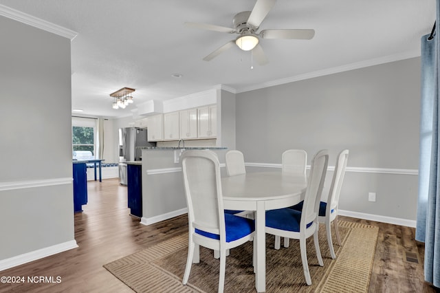 dining area with crown molding, dark wood-type flooring, and ceiling fan