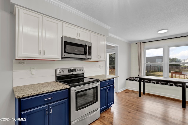 kitchen with blue cabinetry, white cabinets, appliances with stainless steel finishes, and a healthy amount of sunlight