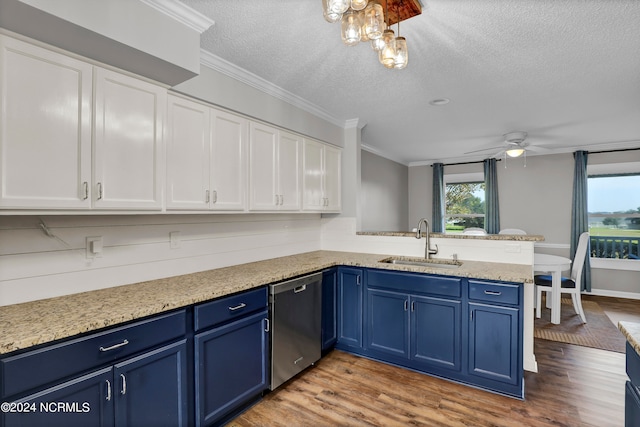 kitchen with sink, ceiling fan with notable chandelier, kitchen peninsula, blue cabinetry, and stainless steel dishwasher