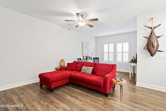 living room featuring ceiling fan and dark wood-type flooring