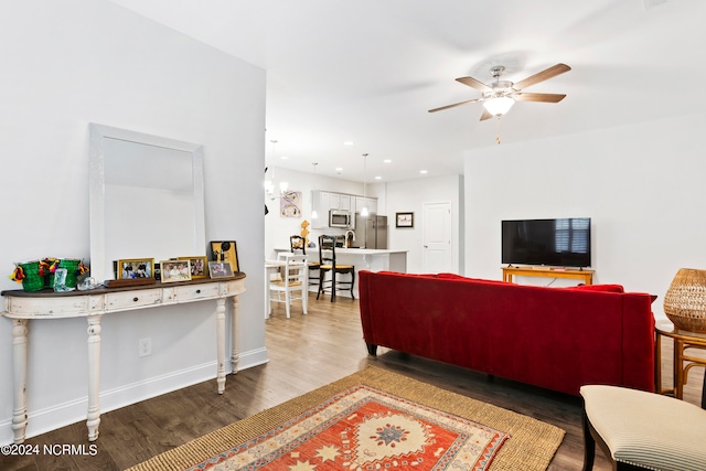 living room featuring ceiling fan and dark wood-type flooring