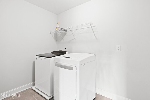 laundry room featuring washing machine and dryer and tile patterned floors