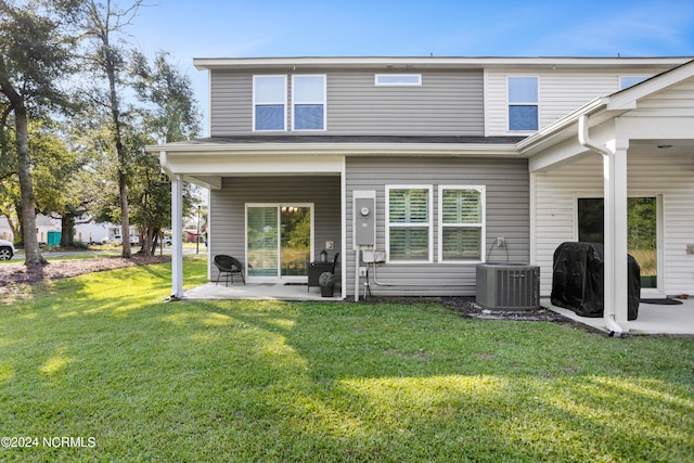 back of property featuring a lawn, a patio, and central AC