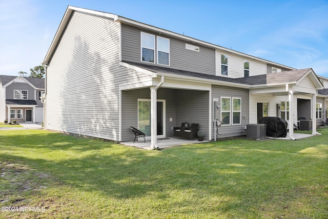 rear view of house featuring a patio, a yard, and central AC unit