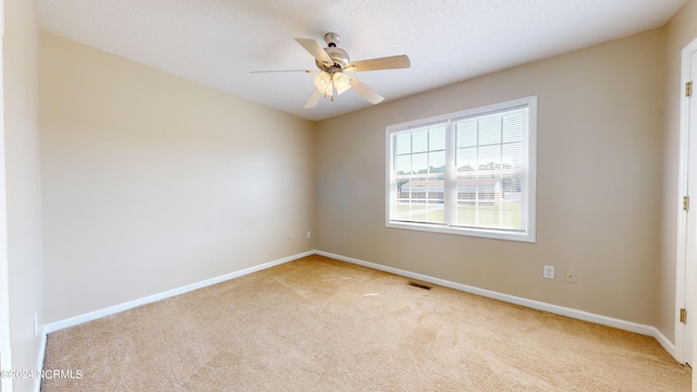 empty room with ceiling fan and light colored carpet