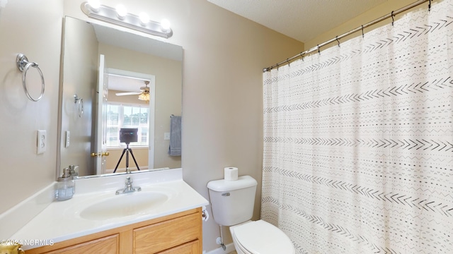 bathroom with a textured ceiling, walk in shower, ceiling fan, vanity, and toilet