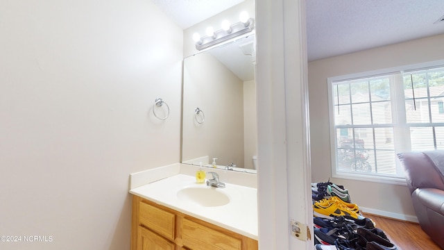 bathroom featuring wood-type flooring, vanity, and toilet