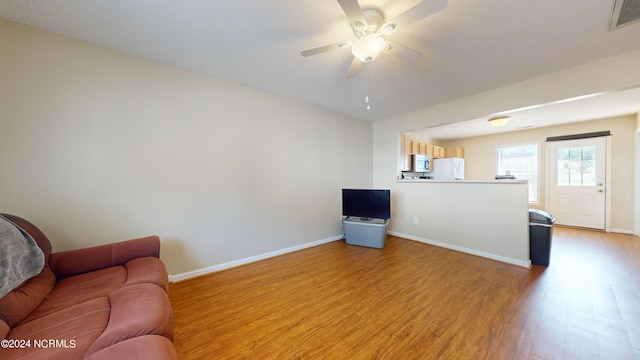 living room with light hardwood / wood-style floors and ceiling fan