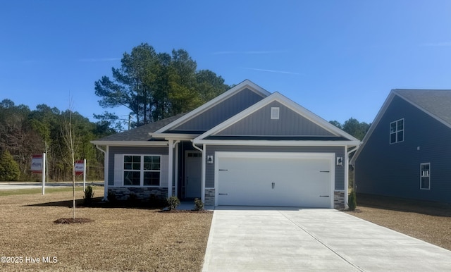 craftsman house with driveway, stone siding, and an attached garage