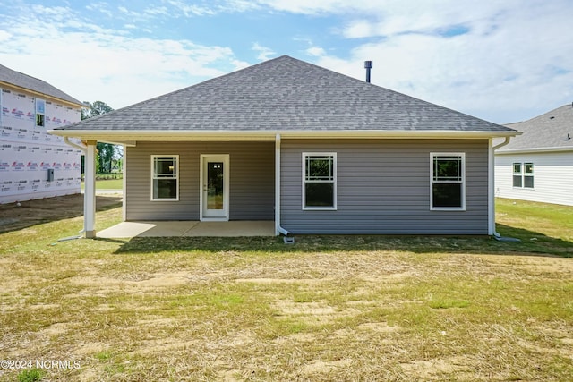 back of house with a patio area and a yard