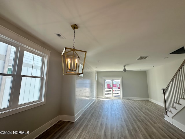 interior space with ceiling fan with notable chandelier and dark hardwood / wood-style floors