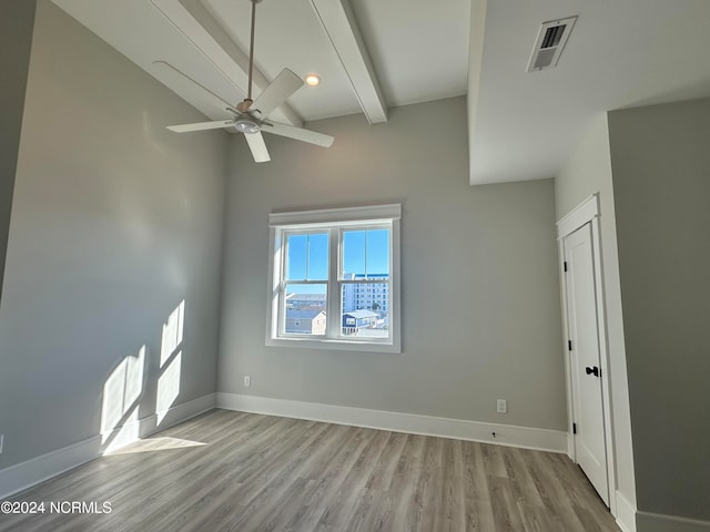 unfurnished room featuring beamed ceiling, light hardwood / wood-style flooring, and ceiling fan