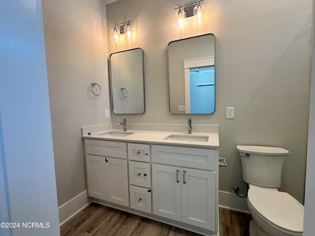 bathroom with toilet, hardwood / wood-style flooring, and vanity