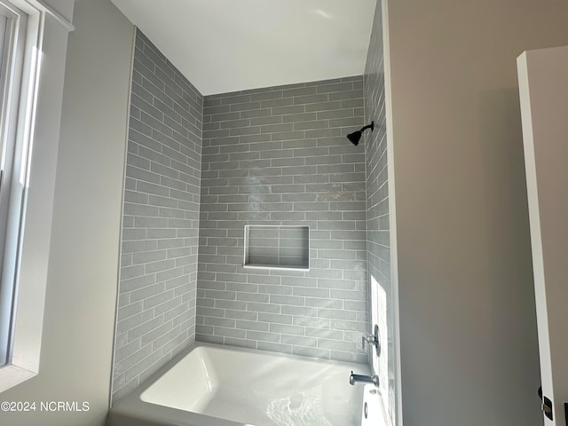 bathroom featuring tiled shower / bath