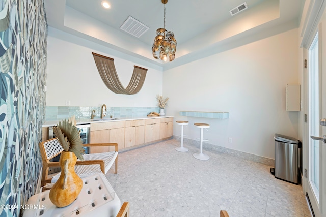 interior space with sink, wine cooler, and a tray ceiling