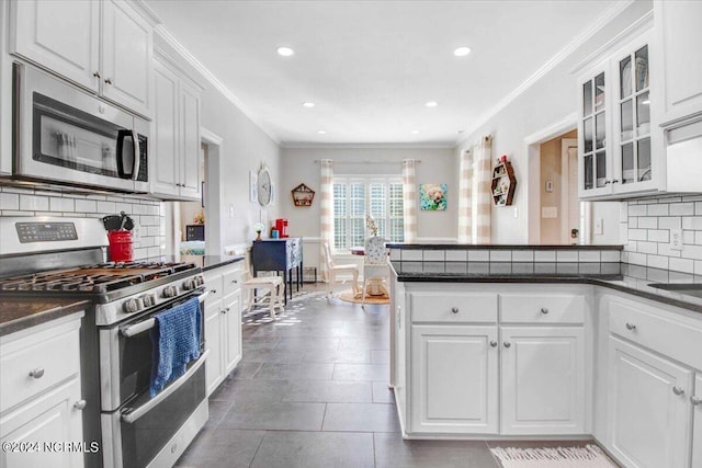 kitchen with appliances with stainless steel finishes, dark countertops, and white cabinets