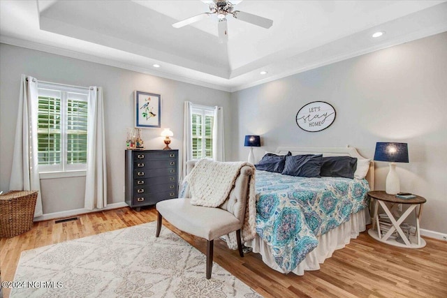 bedroom featuring baseboards, a raised ceiling, ornamental molding, wood finished floors, and recessed lighting