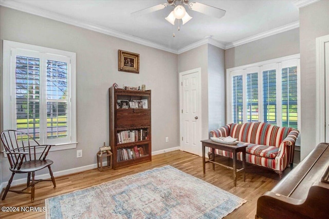 living area with a healthy amount of sunlight, baseboards, ornamental molding, and wood finished floors