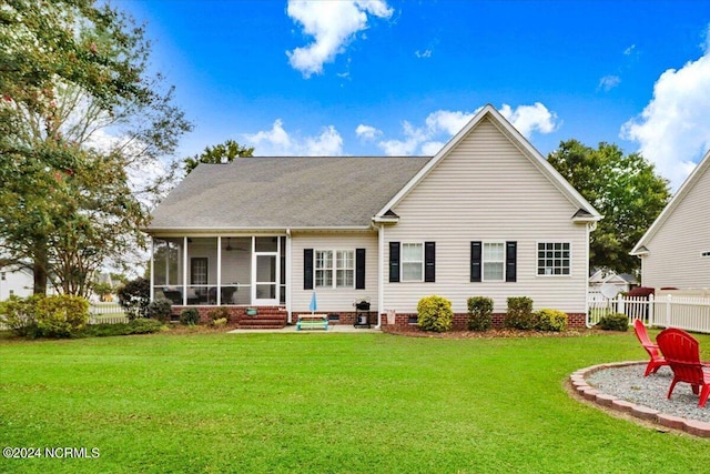 back of house with entry steps, a sunroom, fence, and a lawn