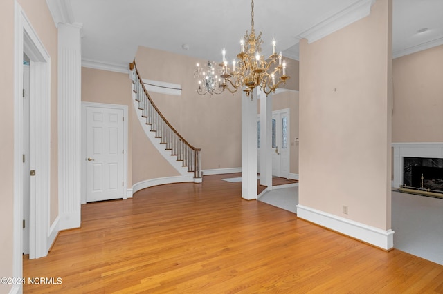 interior space featuring a high end fireplace, ornamental molding, and light wood-type flooring