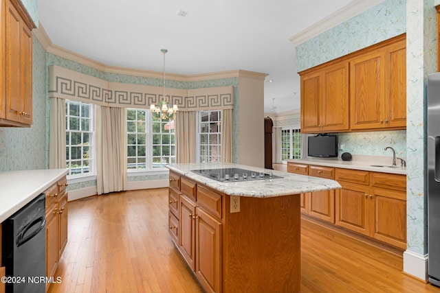 kitchen with a kitchen island, sink, hanging light fixtures, ornamental molding, and black appliances