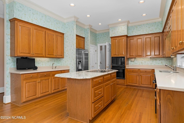 kitchen with a kitchen island, sink, light hardwood / wood-style floors, black appliances, and crown molding