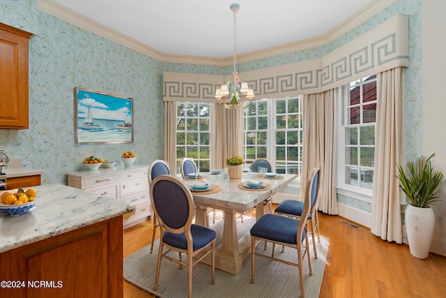 dining space featuring ornamental molding, light hardwood / wood-style floors, and a notable chandelier