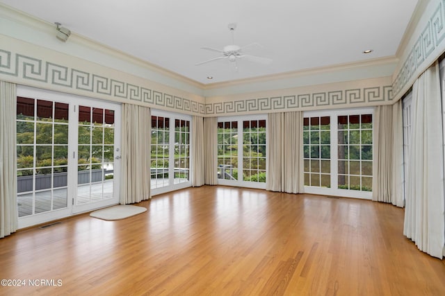 interior space featuring ceiling fan, crown molding, a wealth of natural light, and light hardwood / wood-style floors