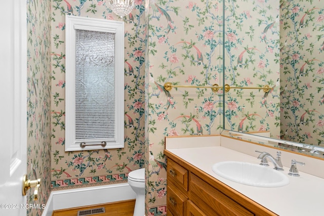 bathroom featuring vanity, hardwood / wood-style floors, and toilet