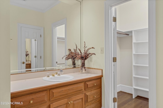 bathroom with vanity, hardwood / wood-style floors, and ornamental molding