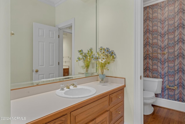 bathroom with ornamental molding, hardwood / wood-style floors, vanity, and toilet