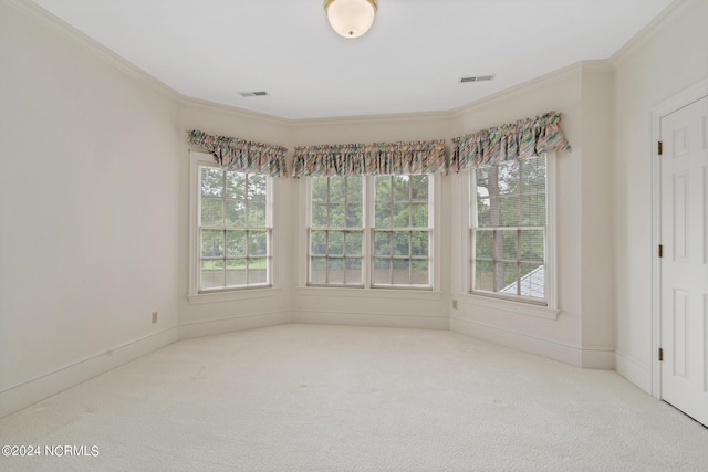 unfurnished room featuring ornamental molding, a healthy amount of sunlight, and carpet flooring