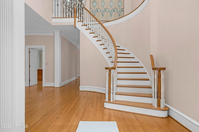 stairway with crown molding and hardwood / wood-style flooring