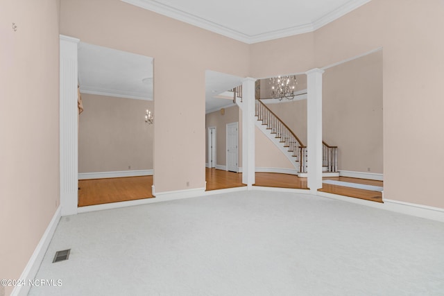 unfurnished room with crown molding, carpet floors, a chandelier, and ornate columns