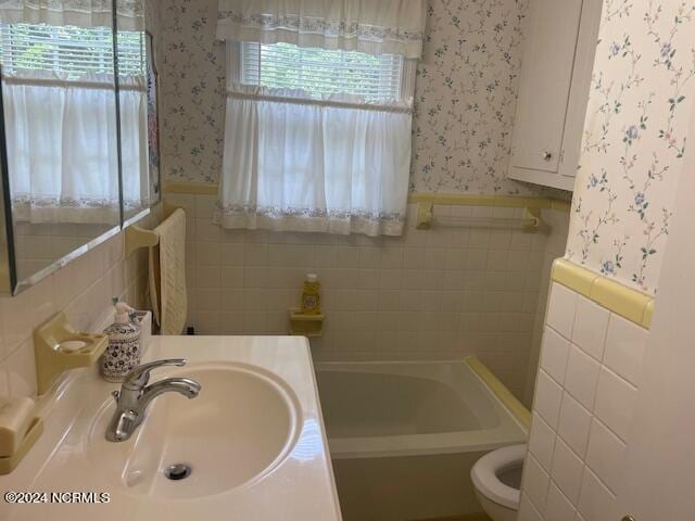 612 David St, Elizabethtown, NC 28337 - full bath featuring wallpapered walls, a sink, tile walls, wainscoting, and a bath
