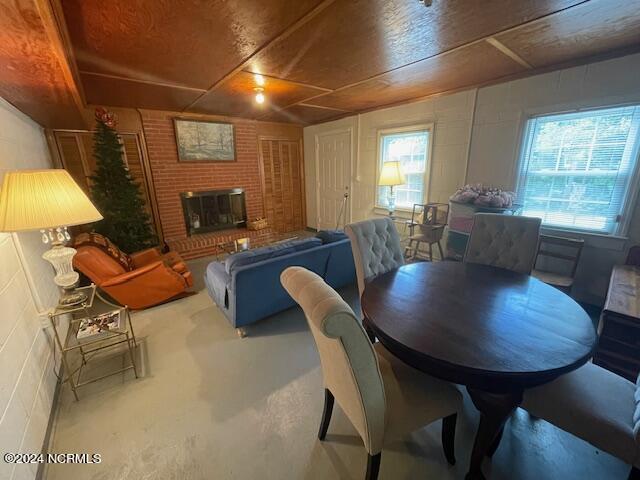 612 David St, Elizabethtown, NC 28337 - dining area with finished concrete floors, concrete block wall, and a brick fireplace
