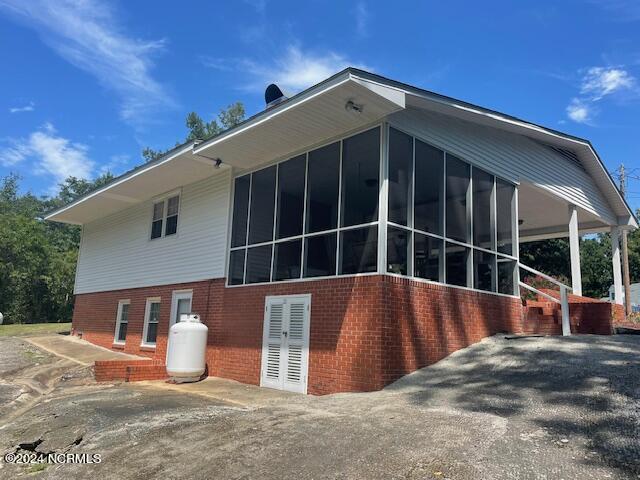 612 David St, Elizabethtown, NC 28337 - rear view of property featuring a sunroom and brick siding