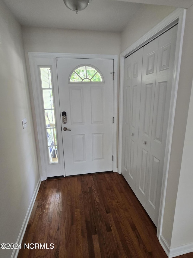 foyer featuring dark wood-style floors and baseboards